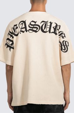 The Pleasures logo arcs boldly across the back of this cozy and oversized waffle-knit cotton T-shirt. 28 1/2" length (size Medium) Crewneck Elbow-length sleeves 100% cotton Machine wash, line dry Imported Casual Ribbed Tops For Streetwear, Streetwear Top With Ribbed Neckline And Drop Shoulder, Ribbed Crew Neck T-shirt For Loungewear, Ribbed Cotton Tops For Streetwear, Oversized Cotton Ribbed Sweatshirt, Oversized Logo Print Tops For Loungewear, Oversized Tops With Logo Print For Loungewear, White Ribbed Tops For Streetwear, Ribbed Cotton T-shirt For Streetwear