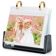 an easel with two girls holding flowers in their hair and wearing wreaths on each side