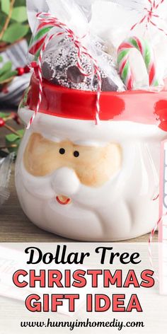 a santa clause mug with candy canes and candies in it, sitting on a table