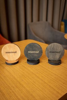 three wooden coasters sitting on top of a table with the words reserved written on them