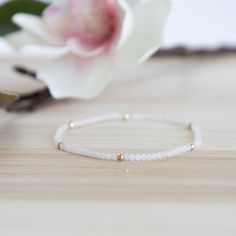 Start your stack with this dainty 2mm Rainbow Moonstone stretch bracelet.  The white/pinkish tint of the rainbow moonstone is accented with 14/20 14k gold-filled beads - resistant to tarnish.  This is one of many of our beautiful layering bracelets that is perfect for a delicate, understated look on its own as well as for parking with our gold filled or sterling silver bracelets in our Classico collection. This bracelet is hand-strung using high quality, Grade A semi-precious gemstones.  It is waterproof and meant to last! Dainty Faceted Beaded Bracelets For Everyday Wear, Dainty Stretch Bracelet With Faceted Beads For Gift, Dainty Stackable Stretch Bracelet As Gift, Adjustable Dainty Stretch Bracelet, Dainty Hand-strung Stretch Bracelet, Delicate Stackable Beaded Bracelets, Delicate Stackable Beaded Bracelets As Gift, Dainty Stretch Bracelet With Tiny Beads, Dainty Beaded Bracelets With Faceted Beads