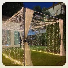 a gazebo covered in white lights and curtains