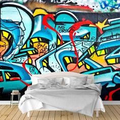 a bed sitting in front of a graffiti covered wall