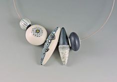 three ceramic objects are hanging on a necklace