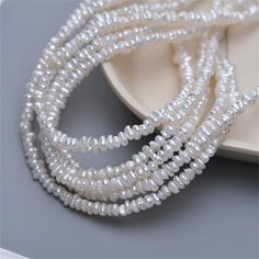 several strands of white glass beads on a plate