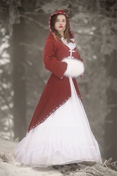 a woman in a red and white dress standing in the snow