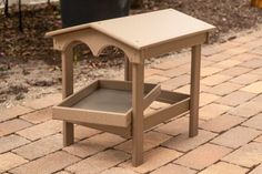 a small wooden table sitting on top of a brick walkway