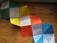 four folded paper squares with writing on them