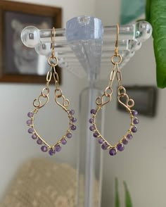 a pair of gold - plated earrings with amethyst beads hanging from hooks