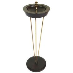 a black and gold stand with two sticks in it's center, on a white background