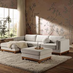 a living room scene with focus on the sectional sofa and footstool in the center