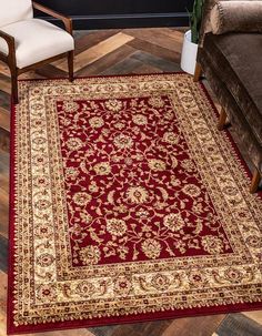 a living room with a red rug on the floor next to a couch and chair