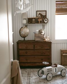 a wooden toy car sitting on top of a dresser in a child's room