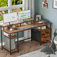 a computer desk with two monitors and a keyboard on it in front of a window