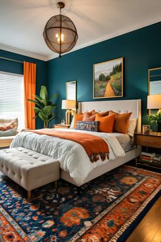 a bedroom with teal walls, orange and white bedding, blue rugs and artwork on the wall