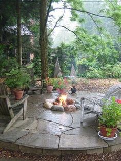 a fire pit surrounded by chairs and potted plants