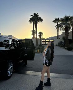 a woman standing in front of a black truck