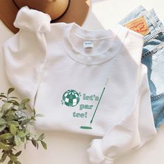 a white sweatshirt with the words let's mar tree on it and a hat next to it