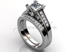 a white gold diamond ring set with two princess cut diamonds on the shoulders and side stones