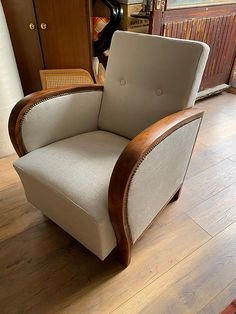 a chair sitting on top of a hard wood floor next to a wooden cabinet and door