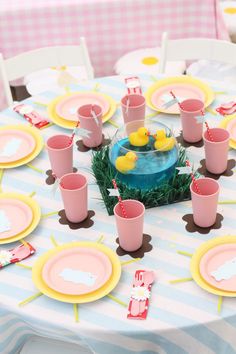 a table topped with pink cups and plates