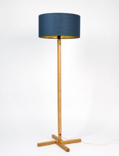 a wooden floor lamp with a blue shade