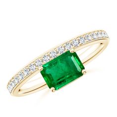 an emerald and diamond ring in yellow gold