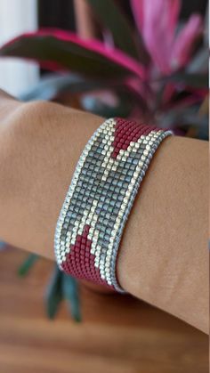 a woman's arm wearing a red and white beaded bracelet on her wrist