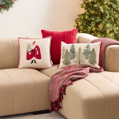 a couch with christmas decorations on it next to a christmas tree