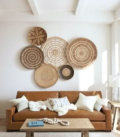 a living room filled with furniture and lots of wicker baskets hanging on the wall