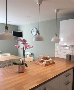 an image of a kitchen counter top with flowers in the center and lights above it