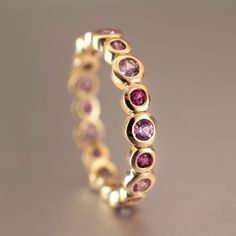 Special shades of natural pink sapphires add a beautiful color splash to this eternity band which is also stackable. This ring is ready to ship in 14K yellow gold, size 7.5 and can be ordered in all other sizes and gold tones upon request. Metal: 14K yellow gold Size: 7.5 Width: 4mm Height: ~2mm Stones: 9x2.5mm light pink natural sapphire, 9x2mm hot pink natural sapphire Stackable Pink Sapphire Jewelry In Pink, Stackable Ruby Eternity Band In Yellow Gold, Ruby Eternity Band In Yellow Gold Stackable, Yellow Gold Ruby Eternity Band Stackable, Fine Jewelry Pink Round Cut Eternity Band, Pink Ruby Stackable Jewelry, Pink Stackable Round Cut Jewelry, Pink Sapphire Stackable Ring In Fine Jewelry Style, Elegant Stackable Pink Sapphire Rings