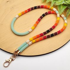 a dog leash with multicolored beads on it and a plant in the background