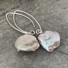 These gorgeous grey keshi pearls have the prettiest lustre with shades of pink and turquoise and occasionally a touch of gold. They are bold and beautiful so needed nothing more than simply hanging from handmade long curved ear wires. The cultured freshwater pearls are really special, they make for a beautiful pair of classy statement earrings. The pearls are all unique random shapes that have a diameter of approximately 12 to 14mm and the total drop of the earrings is approximately 4cm. The photos are of just one of the pairs I have made, as all the pearls are unique the pair you receive may be slightly different, but all will be from the same batch. Your jewellery will be wrapped and packaged into a velvet pouch or a bespoke box. If you would like extra gift wrap and gift card you can ad Keshi Pearl Earrings, Random Shapes, Bespoke Boxes, Ziplock Bags, Jewellery Ideas, Keshi Pearls, Bold And Beautiful, Velvet Pouch, Touch Of Gold