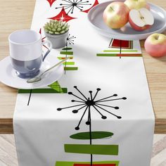 a table topped with an apple next to a bowl of apples and a plate of fruit