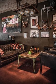 a living room filled with furniture and pictures on the wall