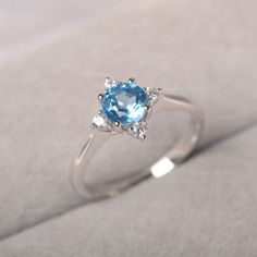 ◆The ring draws inspiration from the polaris. Hand-finished in Sterling sliver, this piece features a round shaped Swiss blue topaz. Clear zirzons decorate around the main stone. An extremely simple celestial ring that you cannot miss. ◆ Production Description: Main stone Type: Swiss Blue Topaz Main Stone Shape: Round Main Stone Size: 6*6mm Side stone: CZ Metal: 925 Sterling silver - Other options available in the drop down menu ◆ Customization: √Free for Add Engraving √Other Metal Type Availabl White Gold Blue Topaz Birthstone Crystal Ring, Light Blue Topaz Ring In Sterling Silver, Blue Topaz Round Birthstone Ring In Fine Jewelry Style, White Gold Birthstone Ring With Blue Topaz, White Gold Blue Topaz Birthstone Ring, Star Engagement Ring, Engagement Ring Minimalist, Topas Ring, July Birthstone Ring