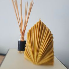 a vase filled with reeds sitting on top of a table