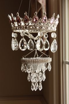 a chandelier hanging from the ceiling with crystal drops and jewels on it's sides