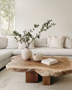 a living room with white couches and a wooden coffee table