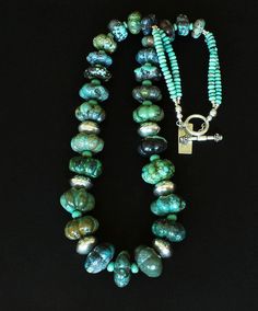 This terrific Necklace displays Graduated Turquoise Flower Beads, ranging in diameter from 20mm to 28mm. The Turquoise Stones are glossy and beautifully cut, and present a range of blues and greens with chocolate & dark brown matrix. The variation in color and pattern has great visual appeal. We've paired the Turquoise with 5mm green Turquoise Rondelles and 6.5mm turquoise & tan Czech Glass Rondelles. These elements are placed between the larger stones, adding dimension & design interest while i Adjustable Turquoise Jewelry With Large Beads, Artisan Round Spacer Beads Jewelry, Turquoise Jewelry With Large Beads For Gift, Gift Turquoise Jewelry With Large Beads, Turquoise Jewelry With Round Spacer Beads, Artisan Jewelry With Large Rondelle Beads, Unique Turquoise Jewelry With Spacer Beads, Handmade Rondelle Turquoise Jewelry, Handmade Turquoise Rondelle Jewelry