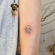 a small dog tattoo on the left upper arm and shoulder, with a circle around it