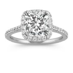 an engagement ring with a cushion cut diamond surrounded by pave diamonds