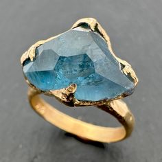 Partially faceted by her husband, this is a Aquamarine Solitaire Ring Wedding Ring Custom One Of a Kind Gemstone Ring Bespoke Three-stone Ring byAngeline Aquamarine surrounded by recycled 14k gold. I hand carved this ring in wax and cast it in solid 14k gold using the lost wax casting process. This one of a kind raw gemstone ring is a size 7 it can be resized up or down for you as needed. The aquamarine stone measures about 12mm X 15mm. The band is about 3mm. Throughout all time and history, in every tribe and culture all around the world crystals, minerals and gemstones have used for healing, luck, divination, adornment vibrational medicine and so much more. Aquamarine is a very soothing and calming stone. Reduces stress and calms the mind It can help with clear communication and is the b Aquamarine Solitaire Ring, Vibrational Medicine, Rough Diamond Ring, Raw Gemstone Ring, Yellow Gold Diamond Ring, Clear Communication, Wax Casting, Lost Wax Casting, Aquamarine Stone