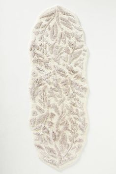 a white piece of cloth with an intricate design on the bottom and sides, sitting on top of a table