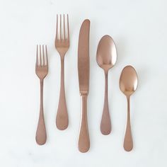 five forks, two spoons and one knife on a white surface