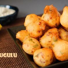 some food is sitting on a black plate and next to a yellow towel with the words puduguli written in it