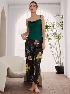 A vintage floral printed pajama set with kimono robe.3pcs: a long robe, a camisole and a long pants.- Black fabric with colorful flowers, contrast green cami and tassel cuffs.- Polyester Charmeuse, silky comfort, machine wash cold.- Removable waist tie closure.- Elastic waistband.- Lapel neckline. - Pearl detailing on straps.- Relaxed fit with a luxurious flowing drape.