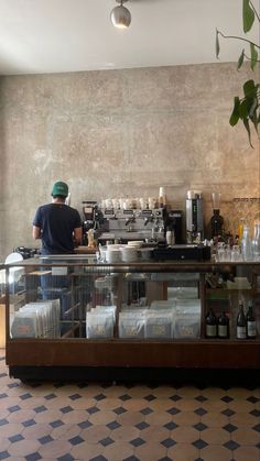 a man standing behind a counter filled with lots of bottles