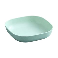 a green bowl sitting on top of a white table